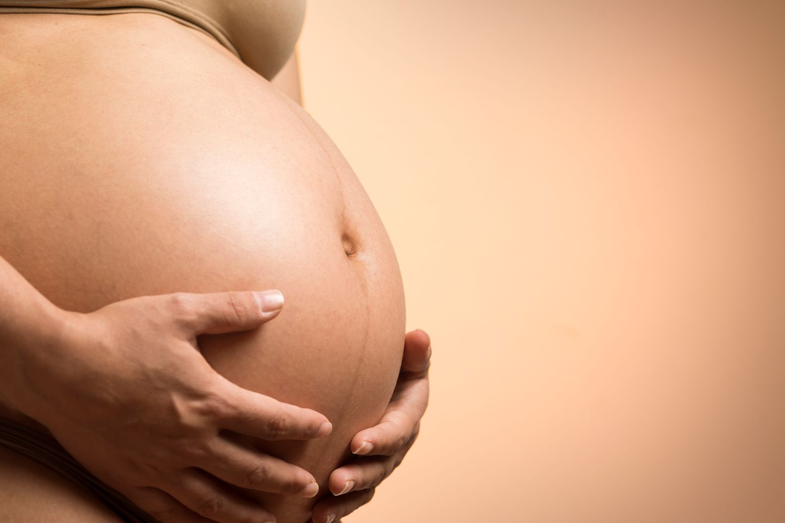 Close maternity portrait focused on a pregnant belly