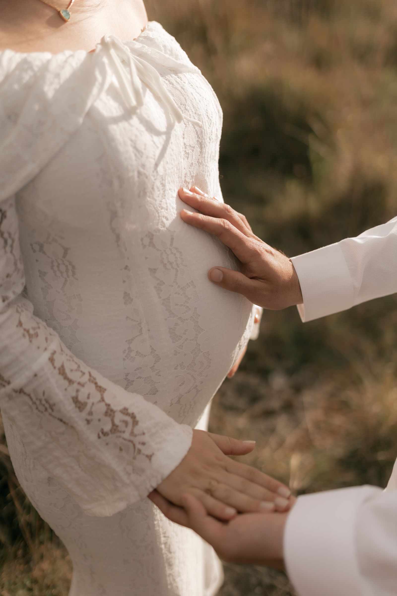 Pregnant person outdoors with a supportive companion