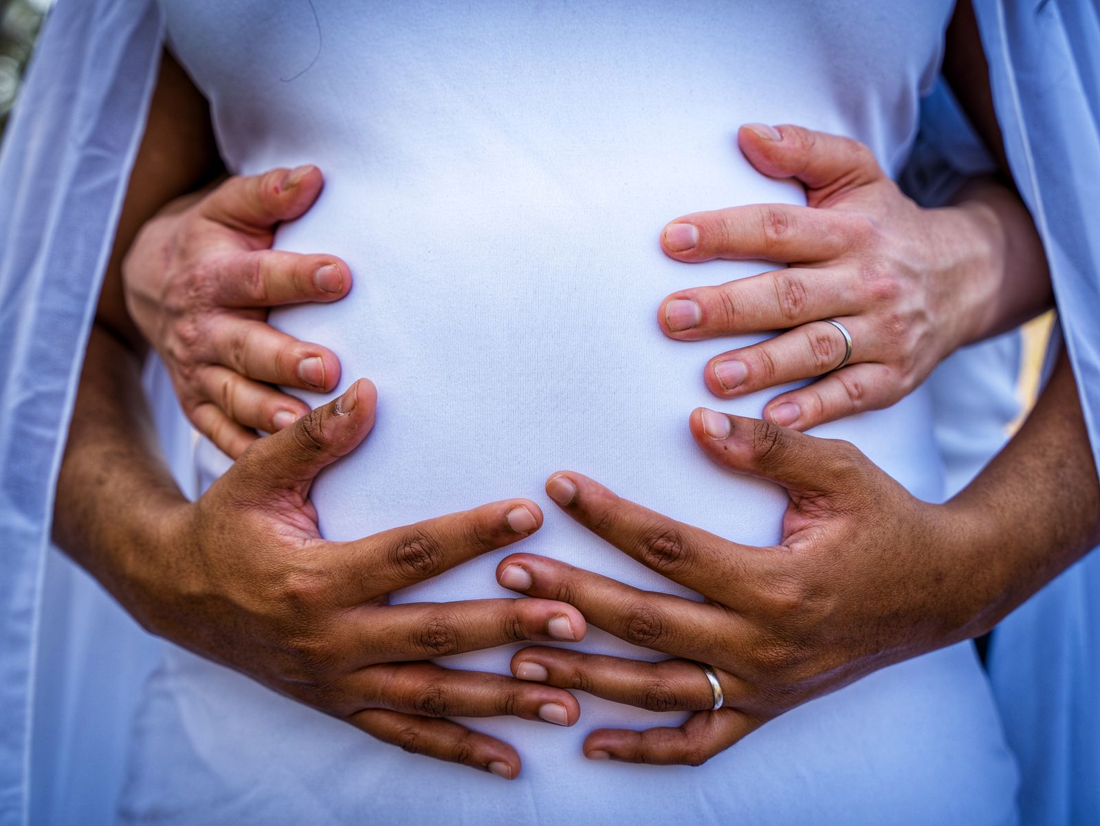 Supportive hands resting on a pregnant belly